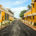 a street in puducherry with houses painted yellow and white on either sides leading upto the coast.