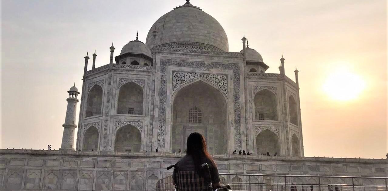 Girl on wheelchair watching the Taj Mahal in the evening sun