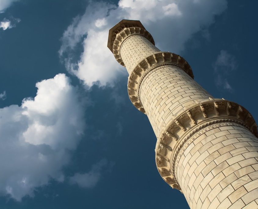 A white marble minaret rising into the bring blue sky