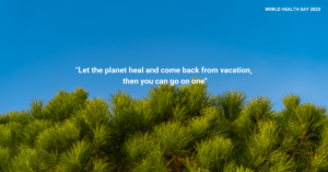 A picture of green trees lined in the background of a clear blue sky. On the picture are the words,‘Let the Planet heal and come back from vacation. Then you can go on one.’