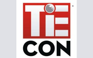 TIECON logo. TIE is written in white on a red background with dot on i as a globe. Con is written in black below it.