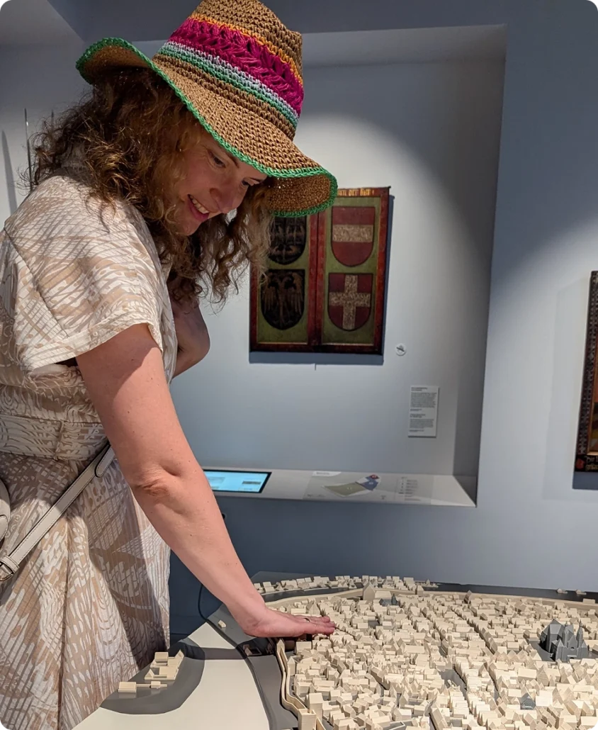 Blind woman exploring a tactile city map in a museum, demonstrating accessible design and inclusive cultural experiences.